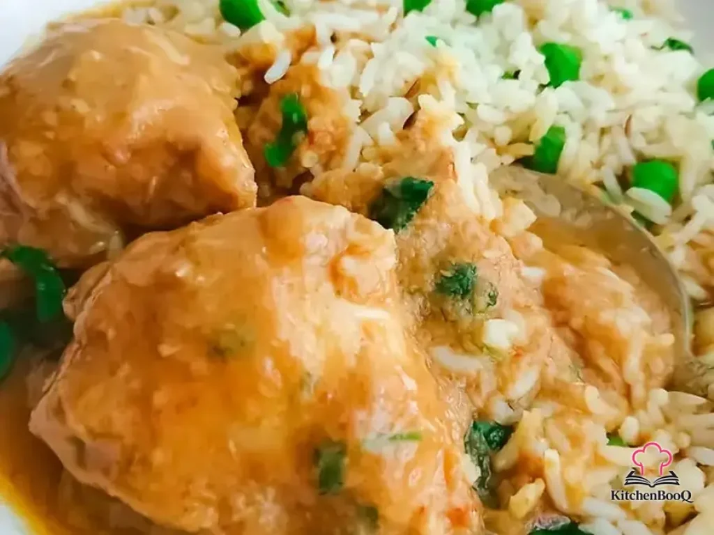 A bowl of 5 ingredient chicken curry with tender chicken pieces in a rich reddish-brown sauce, garnished with dried chilies, served alongside steamed white rice