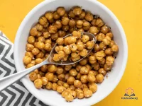 A white bowl filled with golden crispy air fryer chickpeas seasoned with Everything Bagel seasoning on a wooden surface