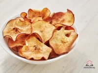 Crispy golden baked apple chips dusted with cinnamon sugar arranged on a wire cooling rack