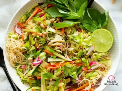 A bowl of Asian noodle salad with capellini pasta, sliced shiitake mushrooms, red bell pepper strips, and fresh parsley in a ginger-soy dressing
