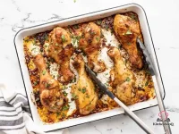 Six golden-brown baked chicken drumsticks on a baking sheet, coated in smoky paprika spice rub with crispy skin