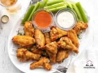 Golden crispy baked chicken wings seasoned with smoked paprika and spices on a wire rack lined baking sheet