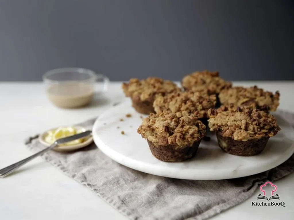 Close-up of banana muffins topped with golden peanut butter granola streusel cooling on a wire rack