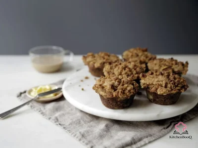 Close-up of banana muffins topped with golden peanut butter granola streusel cooling on a wire rack