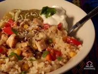 Baja-style chicken bowl with sautéed corn and red bell pepper over brown rice topped with salsa and shredded Monterey Jack cheese