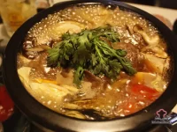 A rustic bowl of beef mushroom and barley soup with tender chunks of beef, pearl barley, and mushrooms in a rich brown broth, garnished with fresh parsley