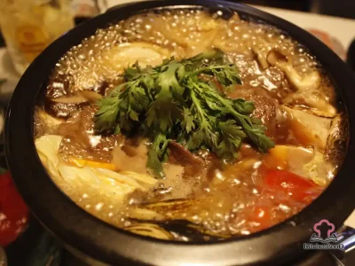 A rustic bowl of beef mushroom and barley soup with tender chunks of beef, pearl barley, and mushrooms in a rich brown broth, garnished with fresh parsley