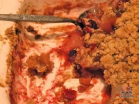 Golden oat-pecan crisp topping over bubbling apples, pears, and cranberries in a rustic baking dish served with cream