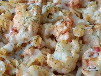Golden bubbling cauliflower tuna pasta bake in a white rectangular oven dish with melted cheese on top