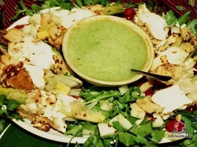 Braised rolled leeks wrapped in golden pie crust strips and filled with creamy cucumber dill ricotta sauce, arranged around a small bowl of cucumber dip on a large serving platter