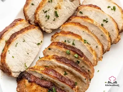 Sliced brown sugar roasted pork loin on a wooden cutting board with a caramelized spiced crust and juicy interior