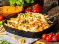 Golden cheesy broccoli pasta bake in a white ovenproof dish with bubbling melted cheddar and mozzarella topping