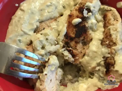 Cheesy salsa verde chicken tenderloins served over cauliflower rice in a skillet, smothered in a creamy green sauce