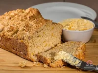 Freshly baked chili cheese cornbread muffins with golden cheddar crust and visible corn kernels on a wooden serving board