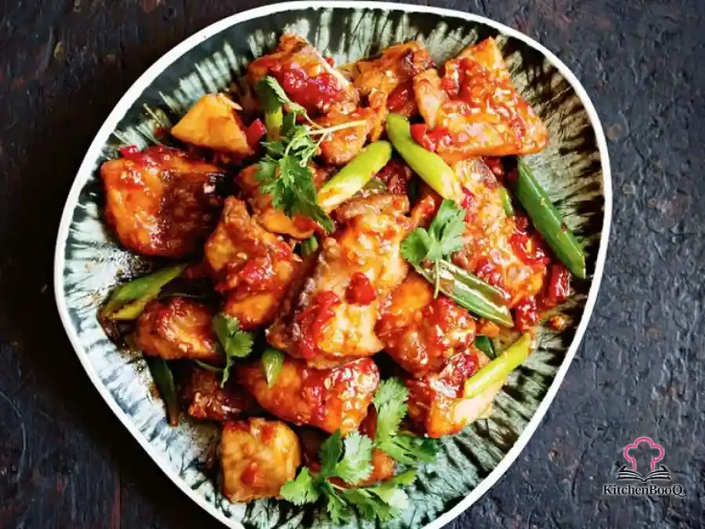 Crispy shallow-fried white fish fillets coated in a glossy Thai three-flavoured chilli tamarind sauce, garnished with fresh coriander and green shallots, served in a bowl with steamed rice